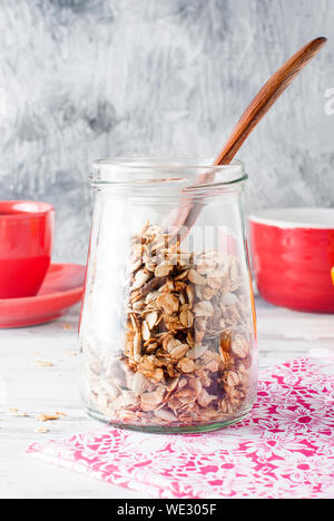 Muesli fatti in casa in un vaso, una sana colazione gustosa farina di avena con frutta e caffè in una tazza, mangiare sano concetto, il fuoco selettivo Foto Stock