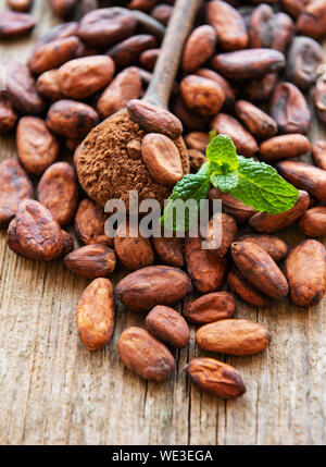 Le fave di cacao e polvere di cacao su un vecchio sfondo di legno Foto Stock