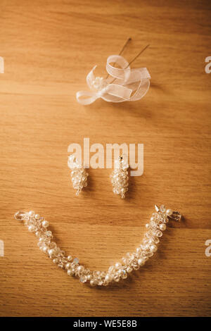 Gli attributi del matrimonio come orecchini collana. Sposa accessori. Accessori di nozze. Dettagli Nozze. Vista dall'alto. Wedding smiley. Sposa gioielli Foto Stock