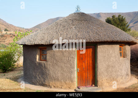 Africana tradizionale argilla rotondo casa con tetto di paglia nel villaggio, Lesotho, Sud Africa, popolo basotho national vecchia casa, montagne Drakensberg Foto Stock