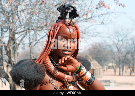 Otjikandero Villaggio Himba, Namibia - 8 Settembre 2017: Bella himba ragazza giovane con la nazionale di acconciatura tradizionali, anelli, collane e bracciali Foto Stock