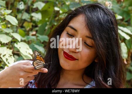 Messico, Michoacan stato, Angangueo, Patrimonio Mondiale dell Unesco, farfalla monarca Riserva della Biosfera di El Rosario, farfalla monarca sulla mano di una donna messicana (Danaus plexippus) Foto Stock