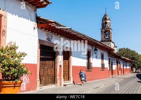 Messico, Michoacan stato, Patzcuaro, tipica strada con case coloniali e San Juan de Dios di clock tower Foto Stock
