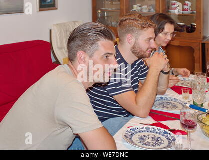 Riunione di famiglia intorno al tavolo a casa Foto Stock