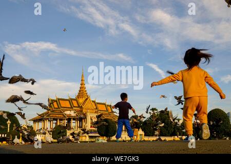 Cambogia, Phnom Penh, il Royal Palace, la residenza del Re di Cambogia, costruito nel 1860, bambini che giocano con i piccioni Foto Stock