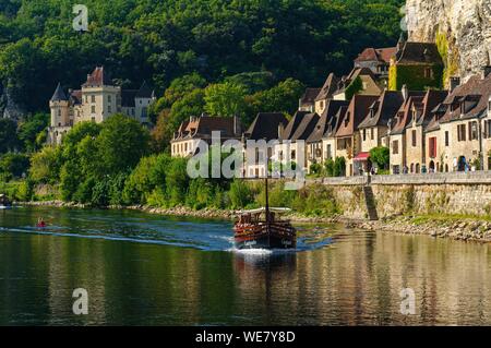 Francia, Dordogne, La Roque Gageac, Gabarra una barca tradizionale, case lungo il fiume Dordogna e sullo sfondo il castello di Malartrie Foto Stock