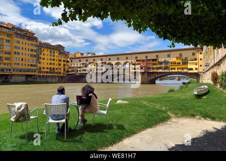 L'Italia, Toscana, Firenze, elencato come patrimonio mondiale dall UNESCO, il Ponte Vecchio visto dal Societa Canottieri Firenze (Firenze Rowing Club), i soci del club aventi un appoggio sul bordo del fiume Arno Foto Stock