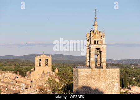 Francia, Vaucluse, parco naturale regionale del Luberon, Cucuron, la Torre dell Orologio o torre campanaria in primo piano e in fondo alla cattedrale di Notre Dame de Beaulieu chiesa Foto Stock