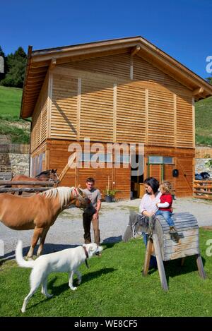 L'Italia, provincia autonoma di Bolzano, Gurschler famiglia con i loro cavalli e il loro cane nella Grushof fattoria alpina, situato sulle altezze di Glorenza Foto Stock