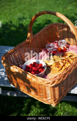 L'Italia, provincia autonoma di Bolzano, Cesto picnic riempito con lamponi e inceppamenti nel giardino del Grushof fattoria alpina situata nelle altezze di Glorenza Foto Stock