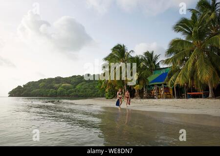 La Colombia, isola di Providencia, giovani donne palme in mano a camminare sulla spiaggia di Suroeste bagnata dal Mar dei Caraibi Foto Stock
