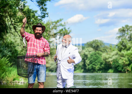 Buona cattura. Uomo Barbuto pesca. La giornata della famiglia. Lucky e qualificati. I filatori e affrontare. Bella la cattura. Esca e gancio. Hobby e ricreazione. La cattura del pesce con un amico. Amici cattura del pesce. Compagno di pescatori. Foto Stock