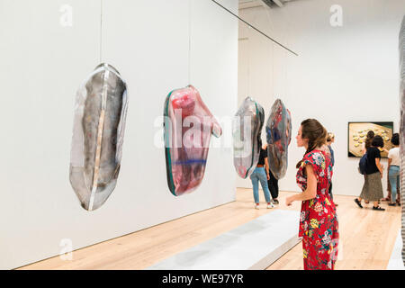 New York Whitney, vista di una giovane donna che guarda al polietilene flottante sculture di Ragen Moss, Whitney Museum of American Art, New York City, Stati Uniti d'America Foto Stock