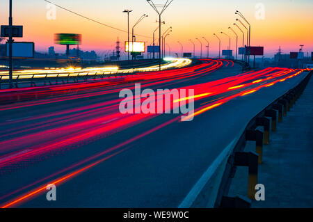 Di notte il traffico della città. Percorsi delle luci auto in autostrada. Foto Stock