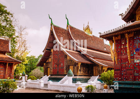 Golden Buddismo arte murale e mosaico di parete alla sala principale di Wat Xieng Thong, Luang Prabang, Laos Foto Stock