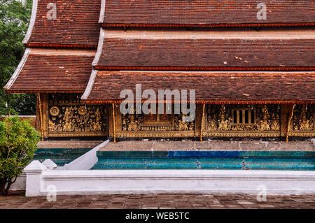 Golden Buddismo arte murale e mosaico di parete alla sala principale di Wat Xieng Thong, Luang Prabang, Laos Foto Stock