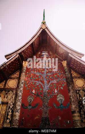 Golden Buddismo arte murale e parete mosaico "l'albero della vita" presso la sala principale di Wat Xieng Thong, Luang Prabang, Laos Foto Stock