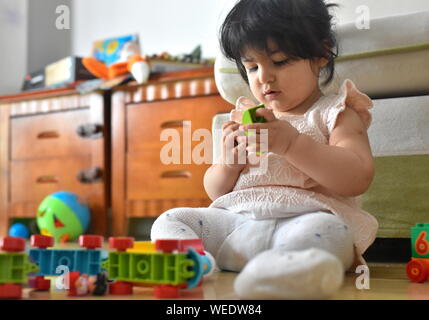 Carino bambina gioca con i giocattoli di apprendimento in vivaio Foto Stock
