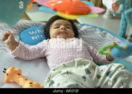 Carino bambina gioca con i giocattoli in attività playmat palestra Foto Stock