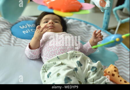 Baby girl svolge attività in palestra playmat Foto Stock