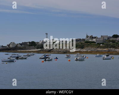 L'île de molène et son merveilleux port et ses bateaux multicolori et ses quais en granit et onu banc bleu et blanc et l'île prise depuis le grandi Foto Stock