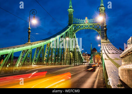 Budapest, Ponte della Libertà di notte con una lunga esposizione e luci auto sentieri Foto Stock