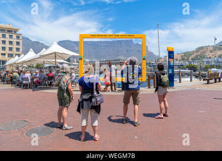 I turisti che posano per una foto nella parte anteriore del Table Mountain, V&A Waterfront, Città del Capo, Western Cape, Sud Africa Foto Stock