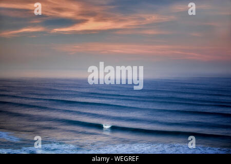 Sunrise e nuvole con onde. Cannon Beach. Oregon Foto Stock