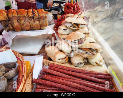 Sapori italiani con lo stallo visualizzazione di prodotti tipici come il maiale arrosto, salsicce e panini, un assortimento di cibo di strada Foto Stock