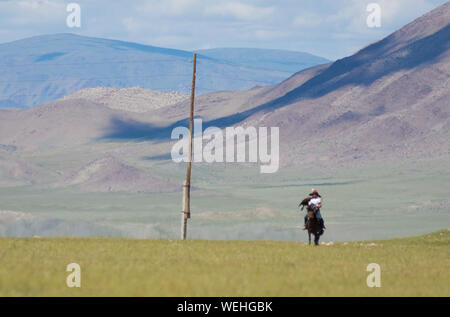 Il kazako eagle hunter a cavallo nella steppa Mongola Foto Stock