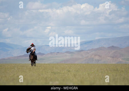 Il kazako eagle hunter a cavallo nella steppa Mongola Foto Stock