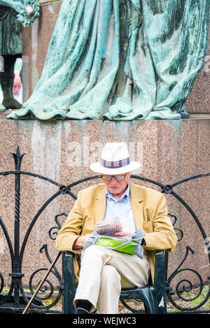 L'uomo con il cappello di Panama di lettura da scultura durante la Edinburgh International Book Festival, Charlotte Square Garden, Scotland, Regno Unito Foto Stock