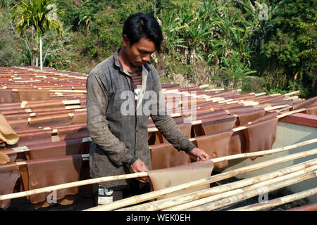 L'agricoltore di gomma si asciuga tappetini in gomma dal liquido raccolto la gomma al San Francesco Eco-Spirituality Centro in Orlong Hada, nello Stato di Meghalaya, India Foto Stock