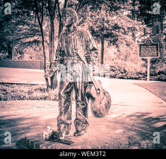 Una statua in bronzo di 13 anno vecchio Elvis con la chitarra si erge sul sentiero tour di Elvis Presley Birthplace Museum motivi in Tupelo, MS, STATI UNITI D'AMERICA Foto Stock