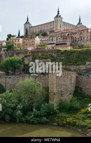 TOLEDO, Spagna - 24 Aprile 2018: l'Alcazar di Toledo e il fiume Tago vista dal ponte di Alcantara. Foto Stock