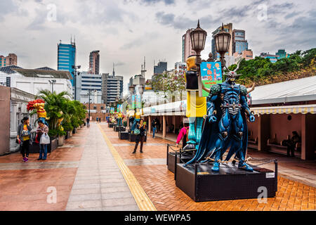 Hong Kong, Cina, Marzo 2013 statue di personaggi famosi, in Hong Kong Avenue di fumetto di stelle, Parco di Kowloon. Urban Skyline sfondo di Tsim Sha Tsui Foto Stock