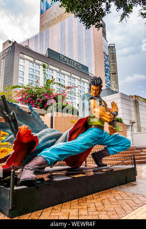 Hong Kong, Cina, Marzo 2013 statue di personaggi famosi, in Hong Kong Avenue di fumetto di stelle, Parco di Kowloon. Urban Skyline sfondo di Tsim Sha Tsui Foto Stock