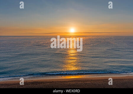 Tramonto sul mare calmo con nebbia Foto Stock