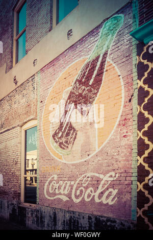 Un vecchio annuncio vintage per la Coca Cola di fading su un vecchio muro di mattoni di un edificio in downtwown Tupelo, Mississippi, STATI UNITI D'AMERICA Foto Stock