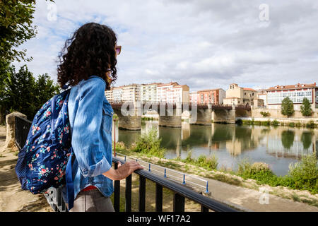 Lei sta guardando lo storico ponte di Carlos III sul fiume Ebro in Miranda del Ebro, provincia di Burgos, Spagna Foto Stock