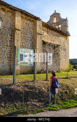 Escursionista femmina la lettura del sentiero del pannello Informazioni a Villanueva de los Montes, Parque Natural de los Montes Obarenes, provincia di Burgos, Spagna Foto Stock