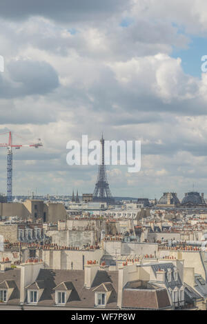 Romantica vista dell'architettura dei tetti degli appartamenti e di commercio di Parigi, con la famosa torre eiffel e punto di riferimento e di una gru a torre in Foto Stock