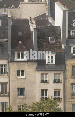 Primo piano e verso il basso in vista di due sottilissime edifici, con rosa e pareti bianche, windows sul tetto, camini di piccole dimensioni e un'architettura vintage con Foto Stock