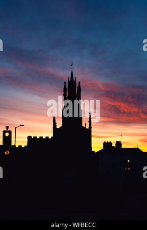 La Porta Est e alla Basilica di San Pietro cappella a sunrise. Warwick Warwickshire, Inghilterra. Silhouette Foto Stock