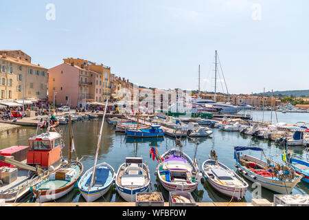 Guardando verso il basso sul vecchio porto di Saint Tropez dal sollevate le mura della città. Il vecchio porto è riempito con i tradizionali, piccole imbarcazioni da pesca, ma nel Foto Stock