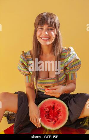 Donna sorridente mangiando anguria Foto Stock