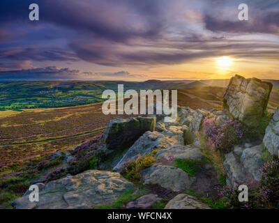 Win Hill, Regno Unito - Agosto 12, 2019: colorato tramonto oltre il Peak District da Win Hill con gli inizi di erica fioritura. Foto Stock