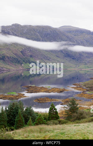 Loch con isole e rosso barca da pesca in movimento attraverso ancora acqua, Highlands scozzesi, Scozia. Foto Stock