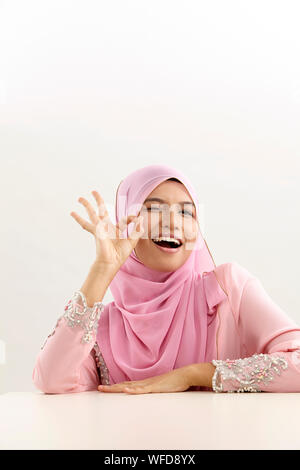 Donna malay con tudung con mano segno ok Foto Stock