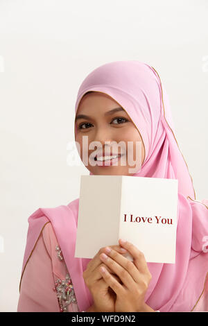 Donna malay con tudung holding ti amo biglietto di auguri Foto Stock